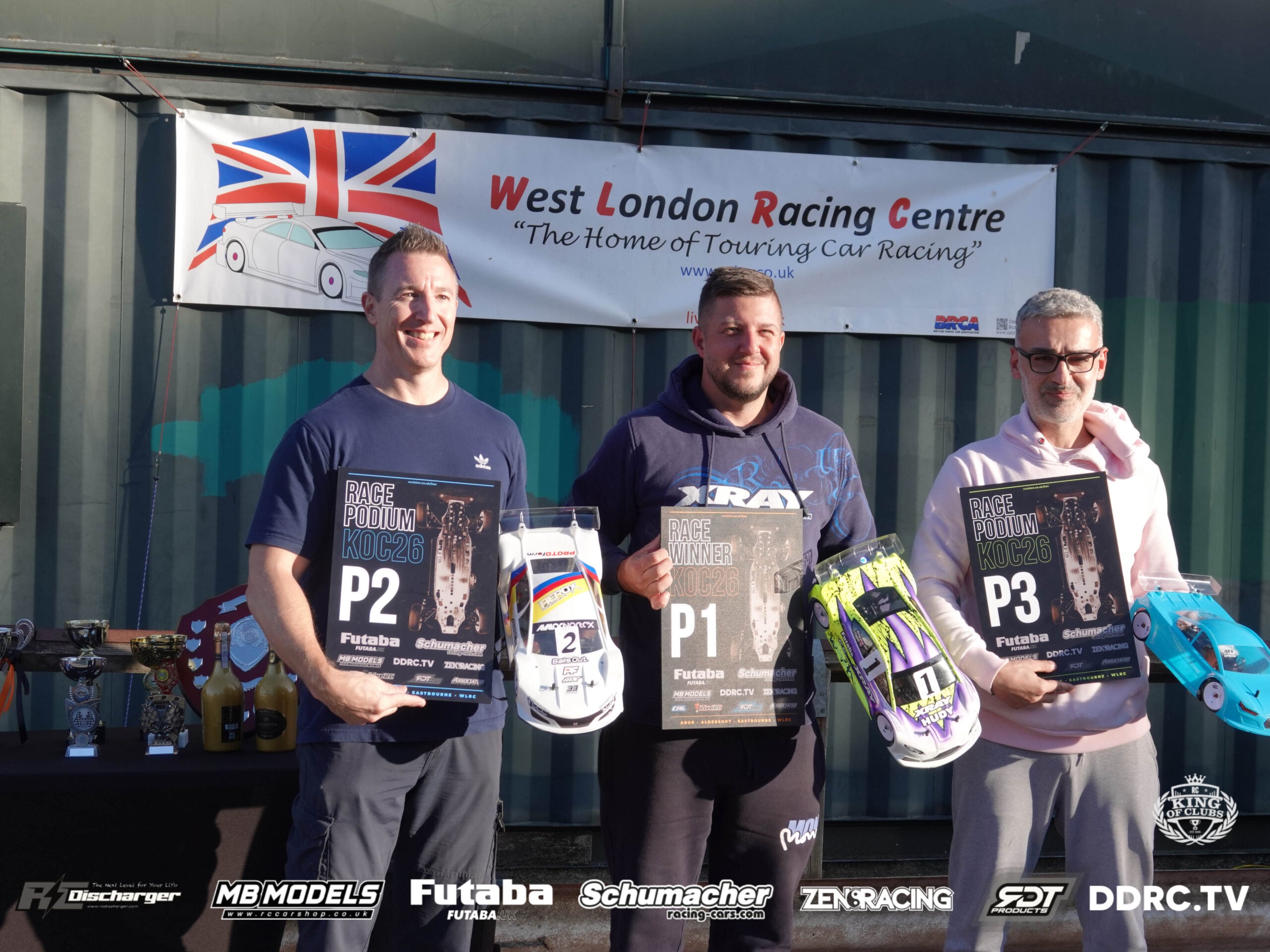 Copsey celebrates his King of Clubs Round 4 win in 17.5 Touring Car at West London Racing Centre, flanked by runner-up Tim Hancock and third-placed Soteris Liasi holding their podium boards.